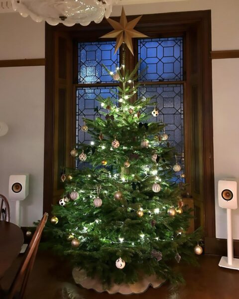 8ft Nordmann Fir Christmas tree with gold baubles and a star topper in front of a leaded window